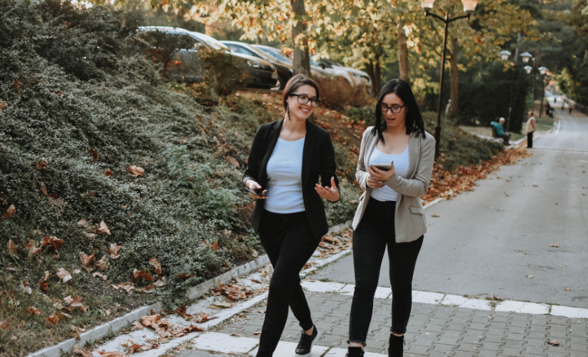 Zwei Kolleginnen beim Walking Meeting an der frischen Luft im Herbst