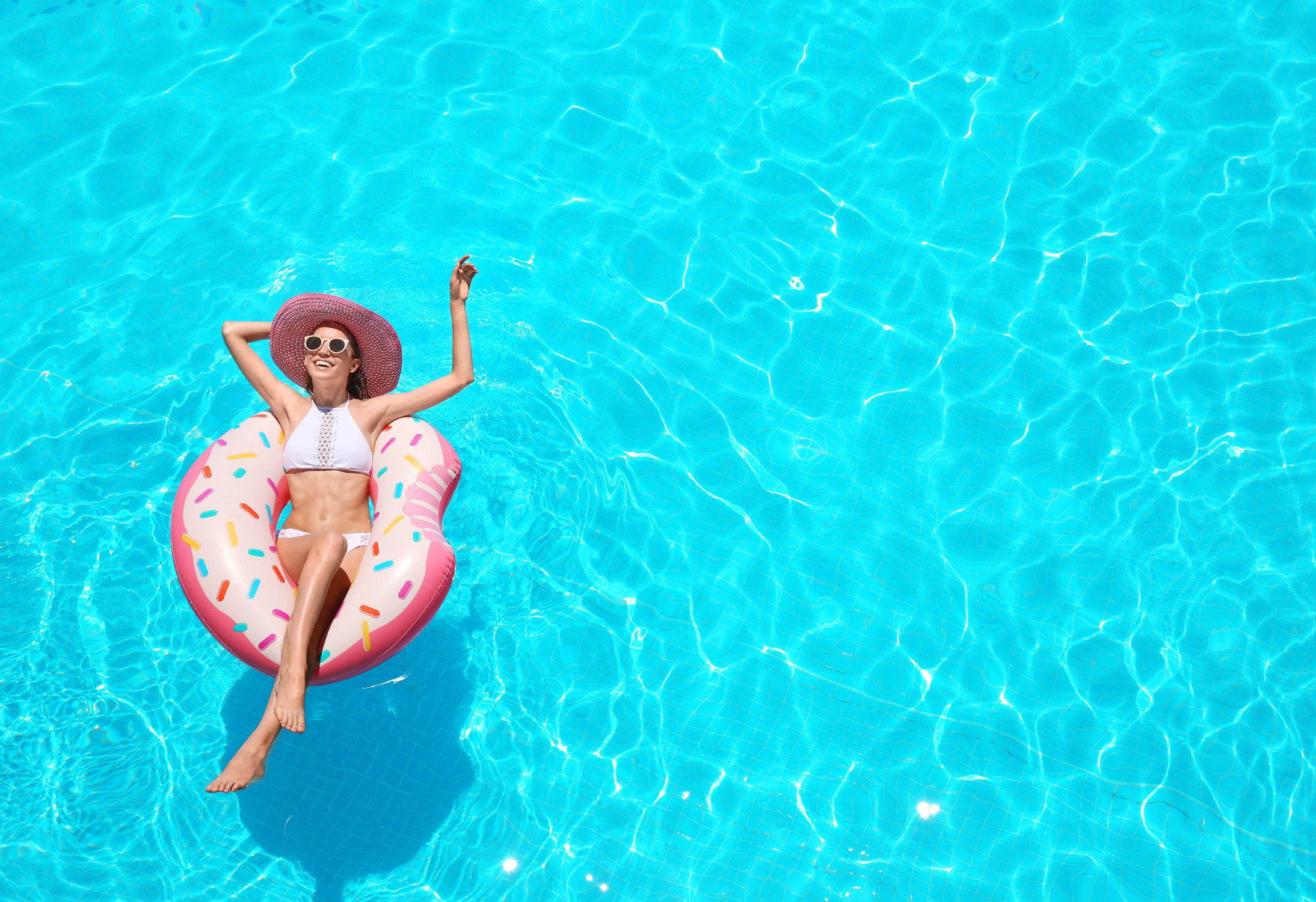 Frau in Donut im Pool, die Quiet Vacationing und freut sich 