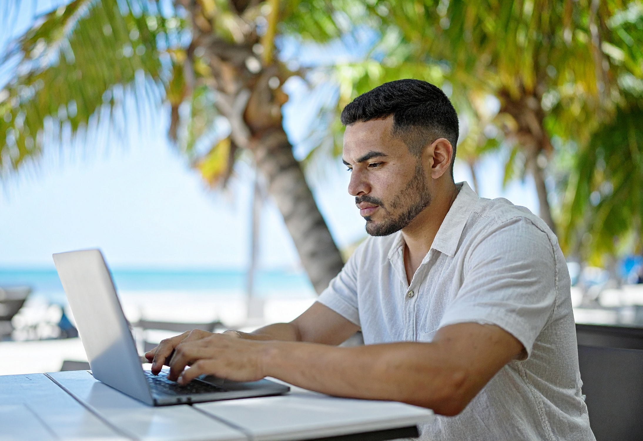 Quiet Vacationing: Mitarbeiter arbeitet heimlich am Strand am Laptop